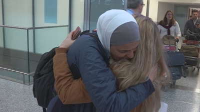 A member of the White Helmets embraces a White Helmet representative in Canada upon arrival at the international airport. 