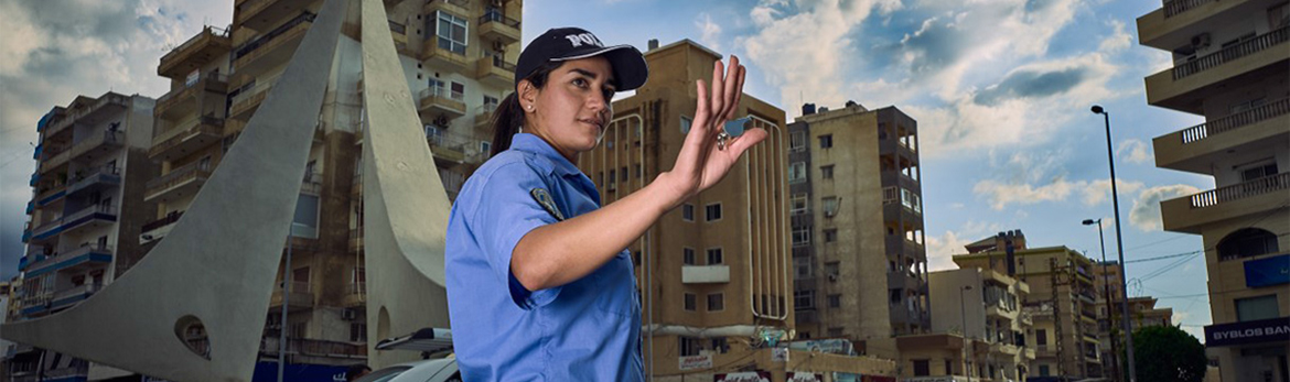 A policewoman directs traffic in Al Mina.