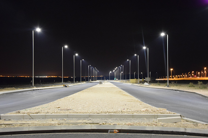 Des lampadaires éclairent la route pendant la nuit.