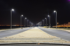Roadway lights lighting up the road at night.