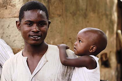 A man holds a young child in his arm.