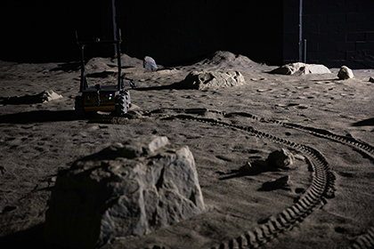 A rover drives around Mission Control’s 4,000-square-foot room that was built to look like the surface of the moon. 