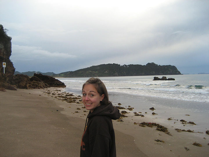 Femme sur la plage, souriant à l'appareil photo