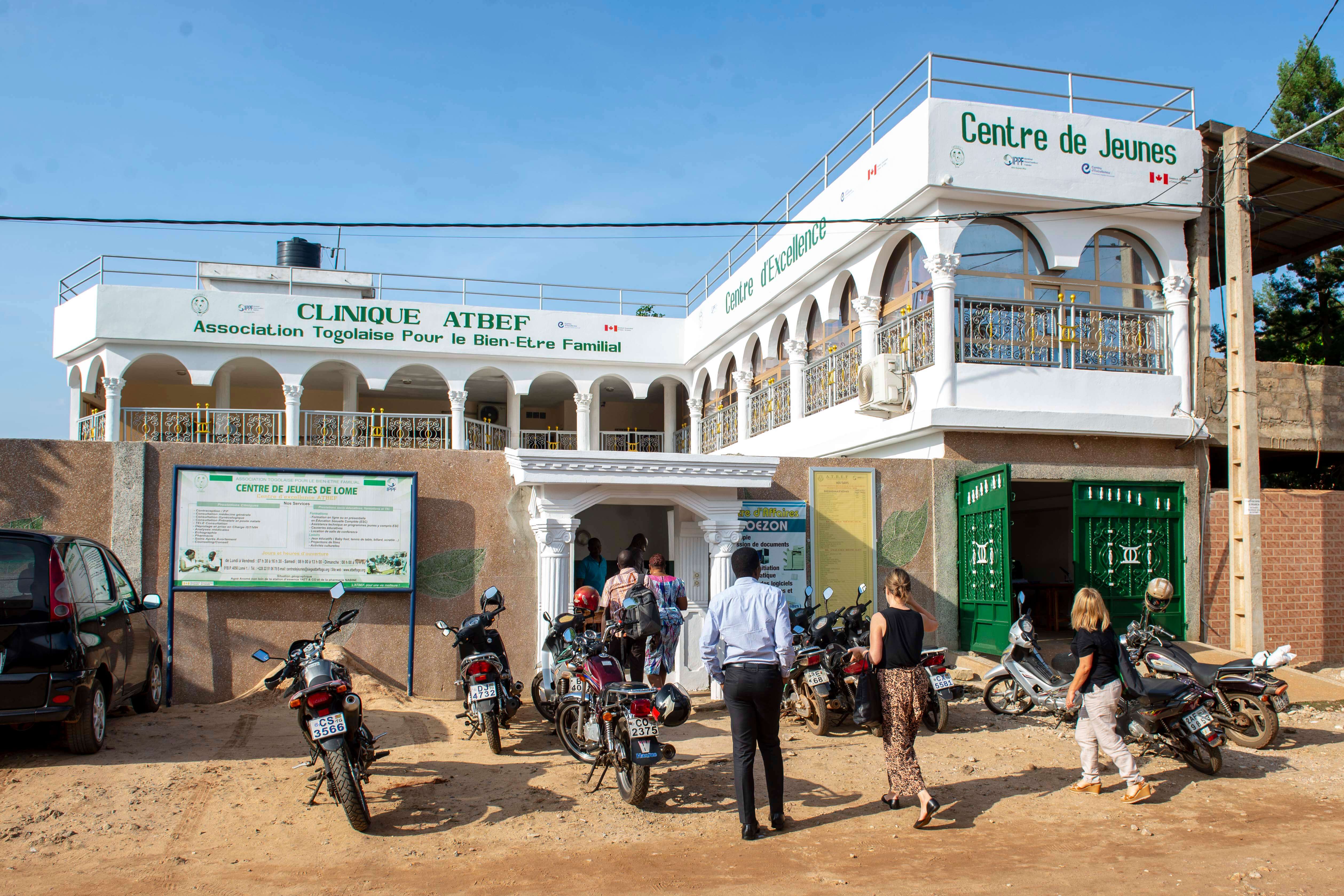 A white 2-story building with people walking into it