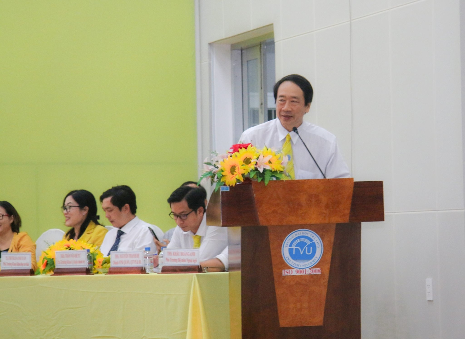 Khanh Phạm Tiet parle dans un microphone sur un podium.