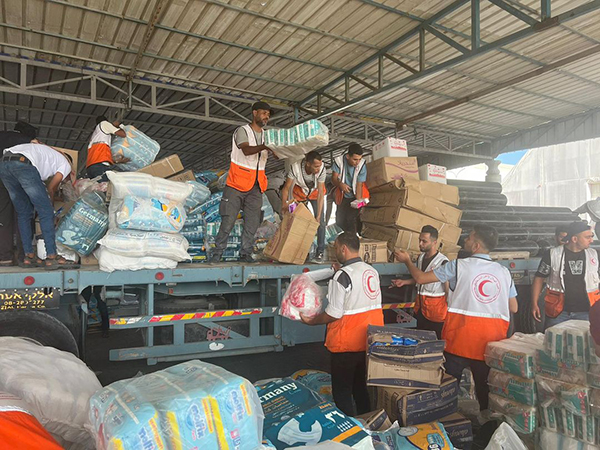 Red Crescent Society personnel unload items from a truck