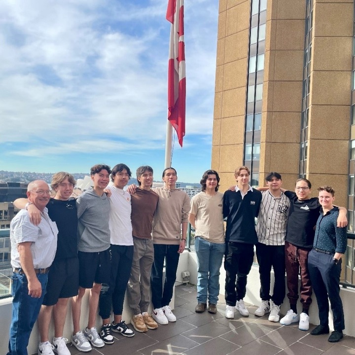 Photo de groupe de 11 personnes devant un drapeau canadien.